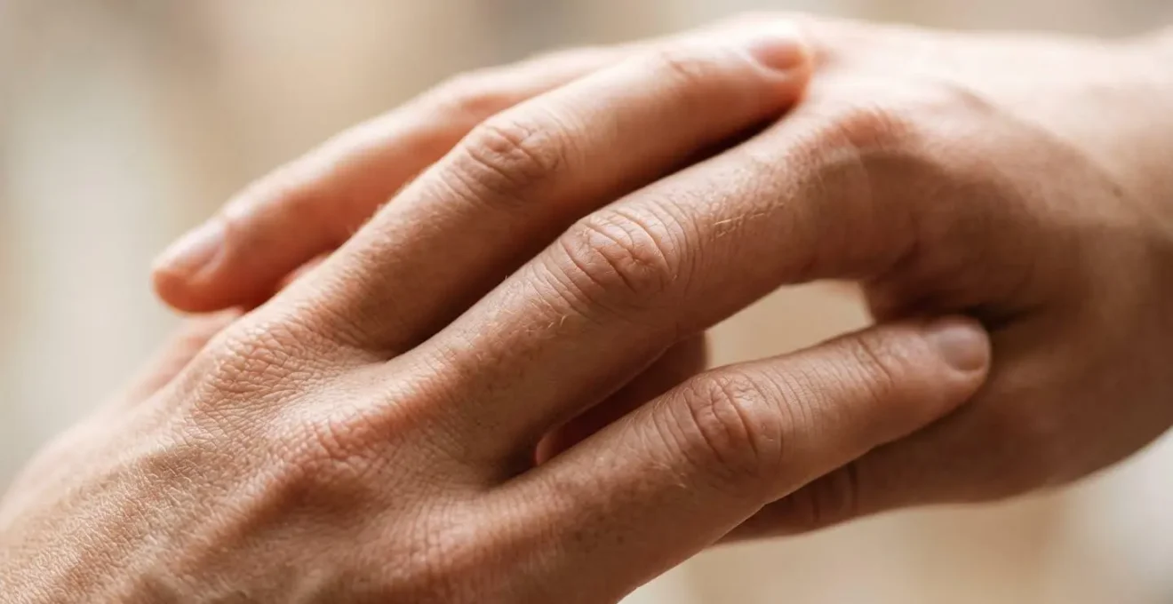 Gros plan macro sur deux mains entrelacées révélant la texture de la peau et l'intimité du contact