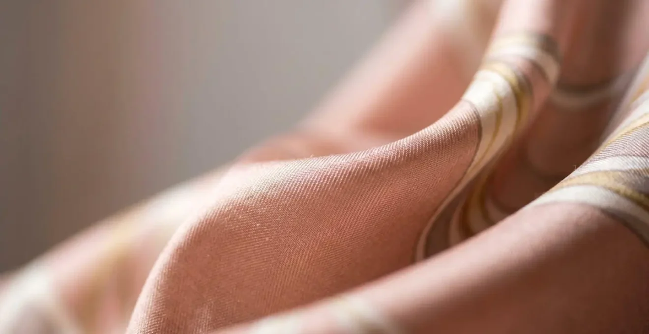 Gros plan sur un foulard en soie de qualité montrant la fluidité et le drapé naturel du tissu